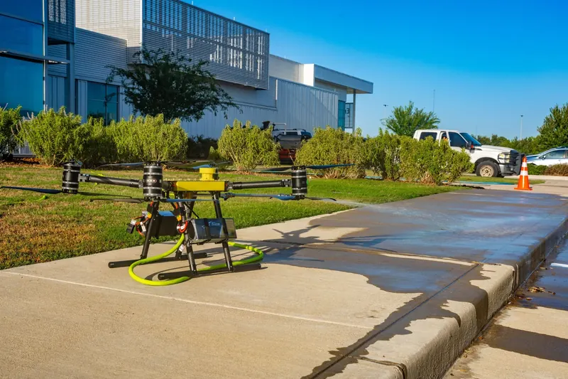 A FlyWash cleaning drone on the sidewalk, ready to fly